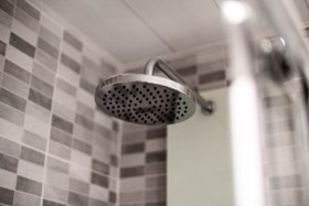 A view of a shower with tiles ranging from black, gray, and white.