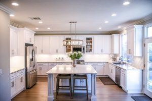 White wooden cupboards and brown laminate flooring in the kitchen